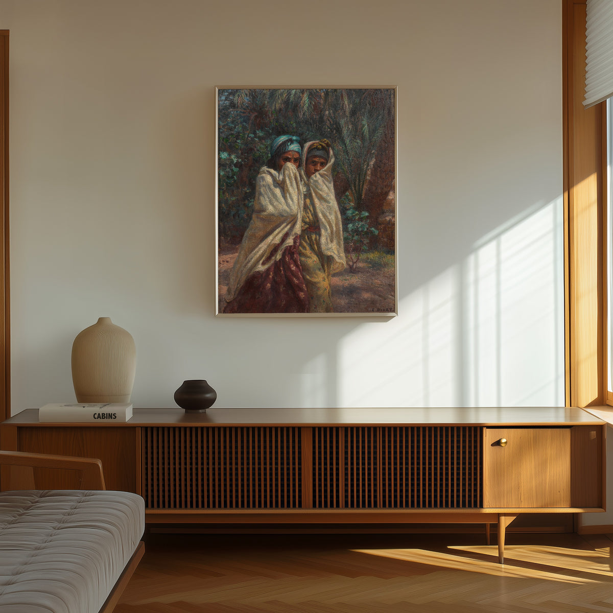 Framed art print of Jeunes filles revenant de la fête, claire de lune by Étienne Dinet, in a thin light frame on a sunlit wall above a wooden sideboard