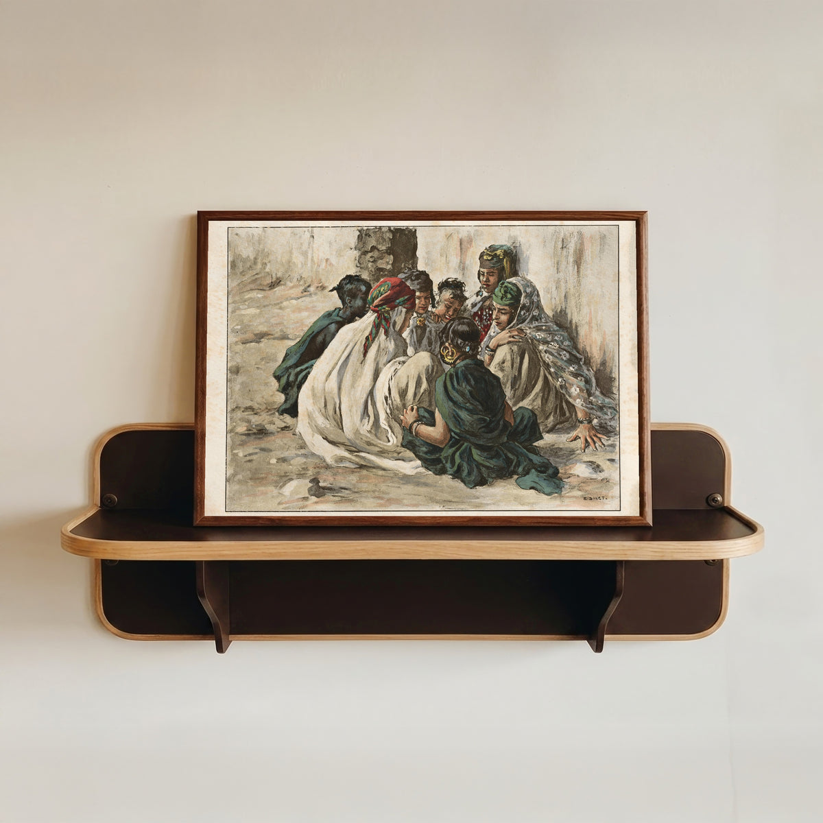 Framed art print of Jeux de fillettes à Laghouat by Étienne Dinet, in a dark wood frame resting on a wall shelf