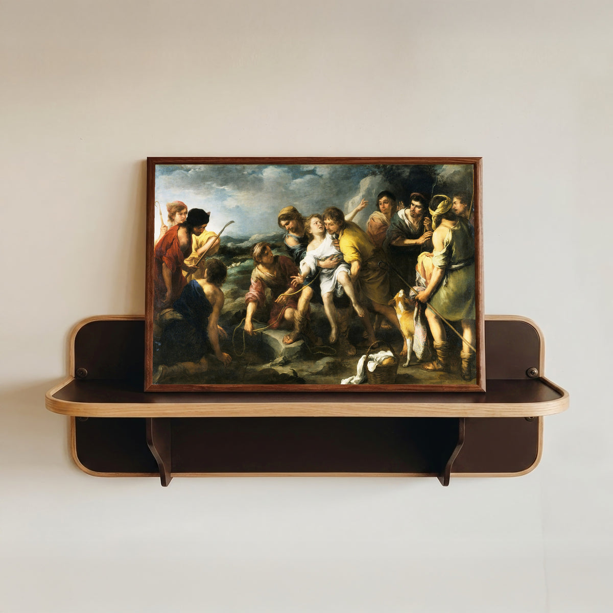 Framed art print of Joseph and his Brethren by Bartolomé Esteban Murillo, in a dark wood frame resting on a wall shelf