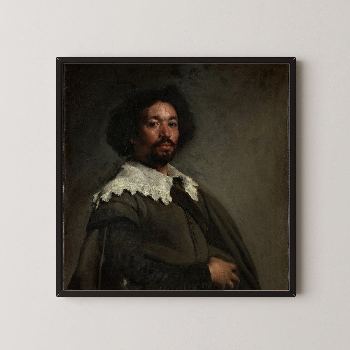 Framed art print of Juan de Pareja by Diego Velázquez, in a black frame on a pale wall