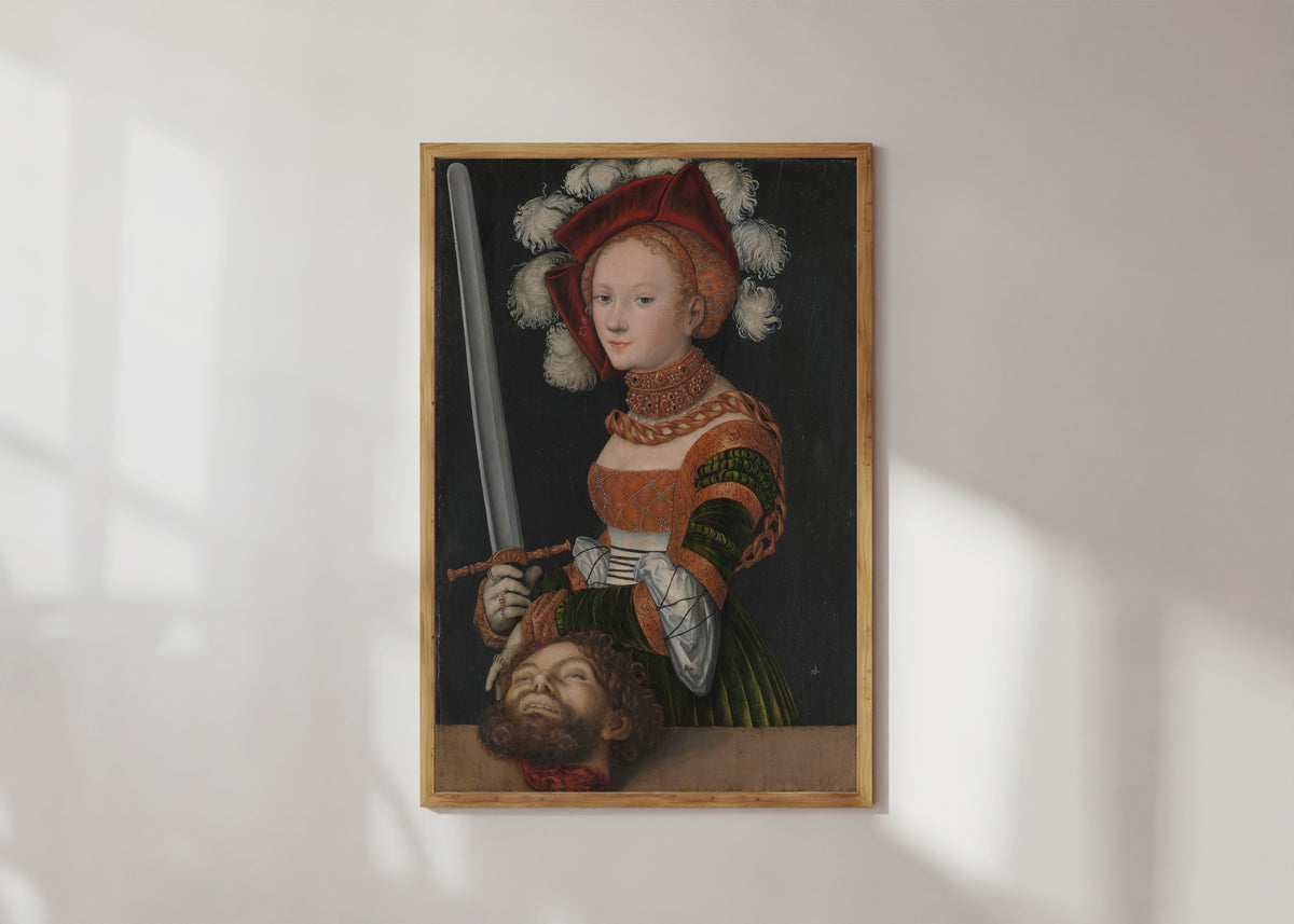 Framed art print of Judith with the Head of Holofernes by Lucas Cranach the Elder, in a light wood frame on a sunlit white wall