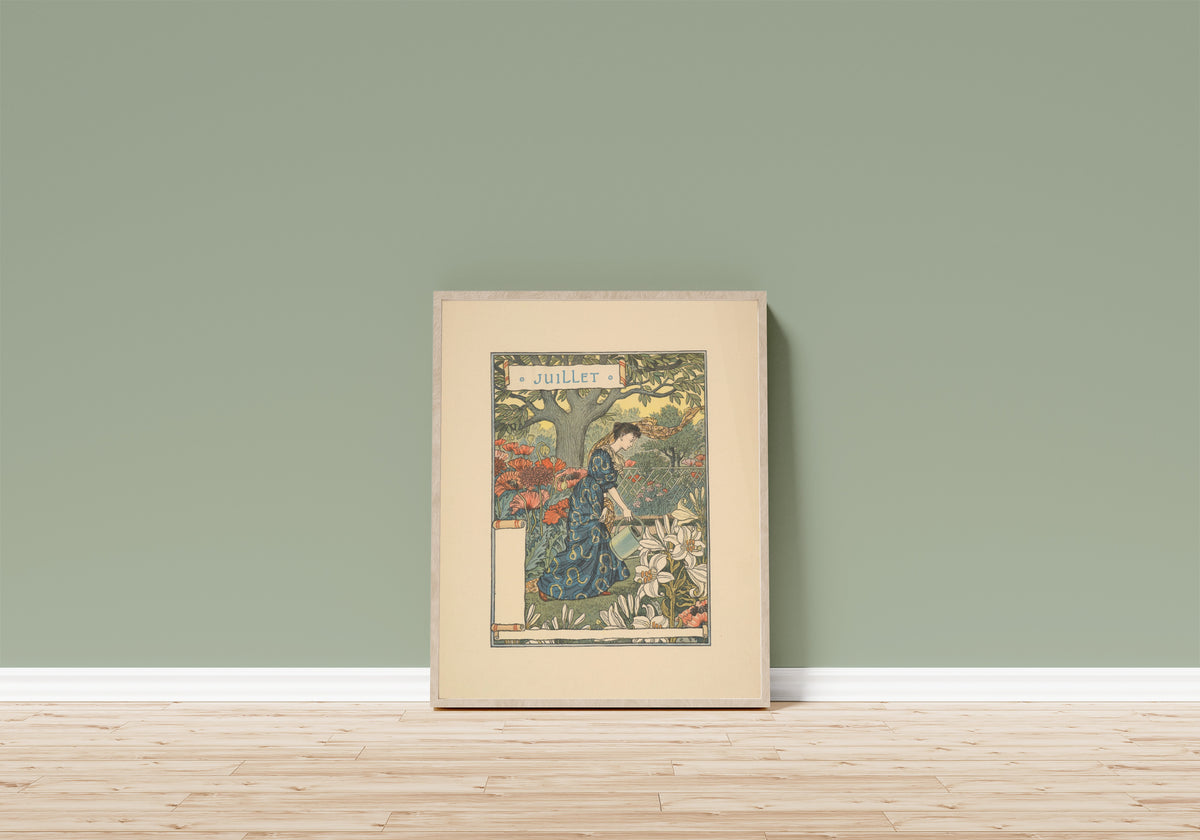 Framed art print of Juillet by Eugène Grasset, in a light wood frame leaning on a sage green wall above a wooden floor
