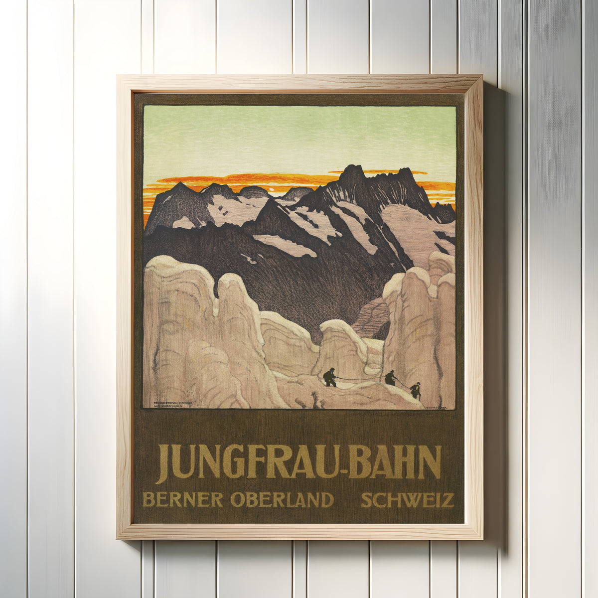 Framed art print of Jungfrau-Bahn: Berner Oberland, Schweiz by Emil Cardinaux, in a light wood frame on a white panelled wall
