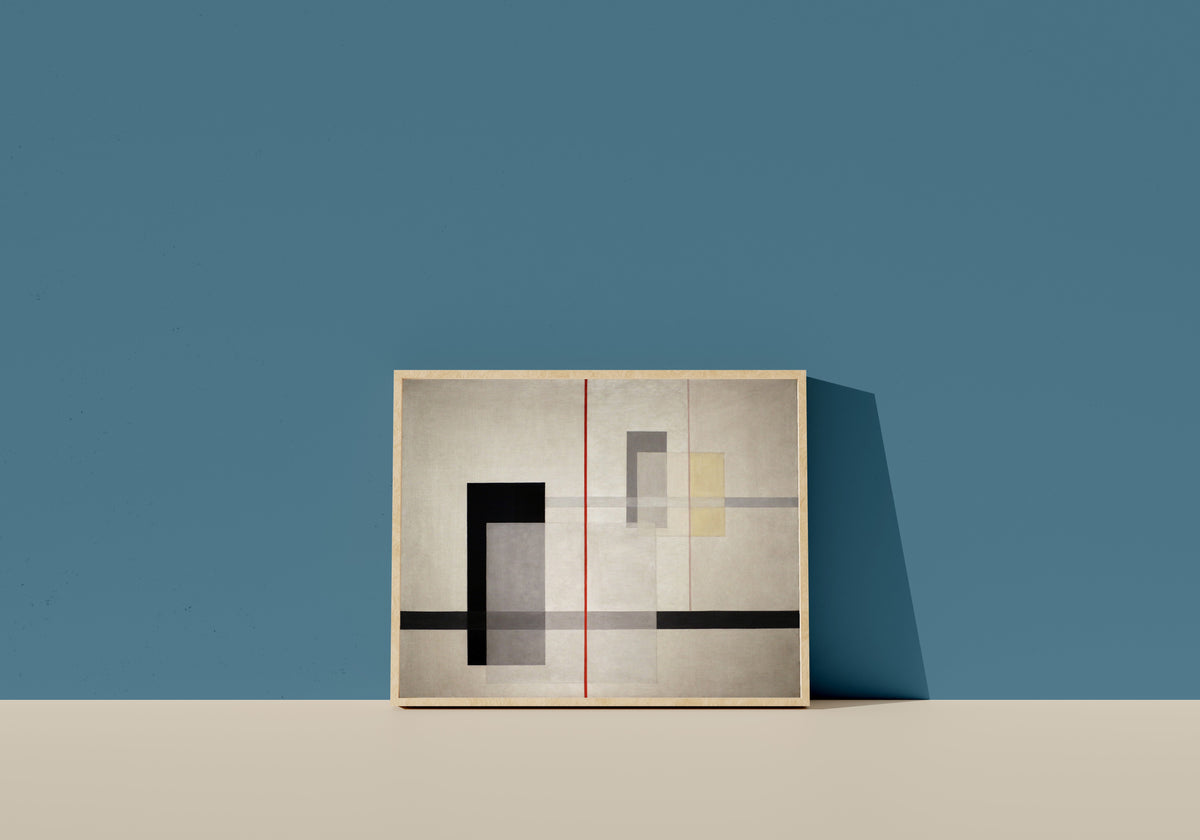 Framed art print of K VII by László Moholy-Nagy, in a light wood frame leaning on a blue wall