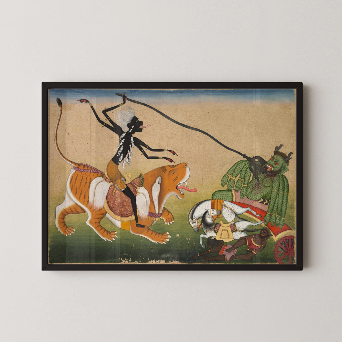 Framed art print of Kali Attacking Nisumbha by Pahari school, in a black frame on a pale wall