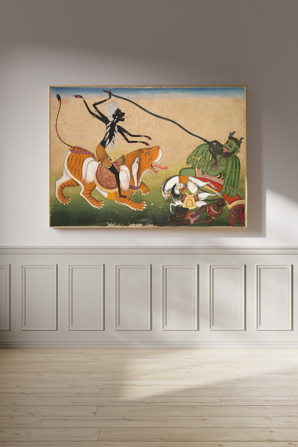 Framed art print of Kali Attacking Nisumbha by Pahari school, on a panelled wall in afternoon light