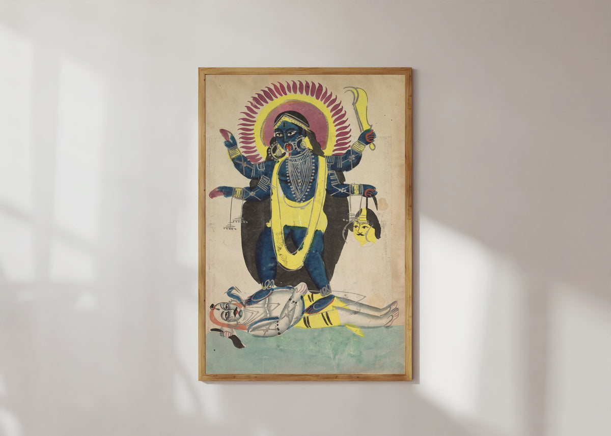 Framed art print of Kali Dancing on Shiva by Kalighat painter, in a light wood frame on a sunlit white wall