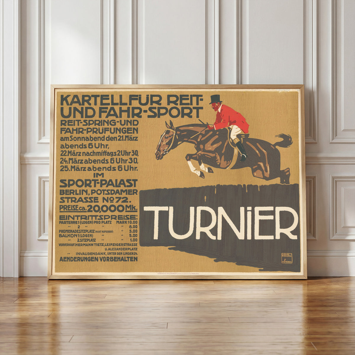 Framed art print of Kartell für Reit- und Fahr-Sport: Turnier by Ludwig Hohlwein, in a light wood frame leaning against a panelled white wall