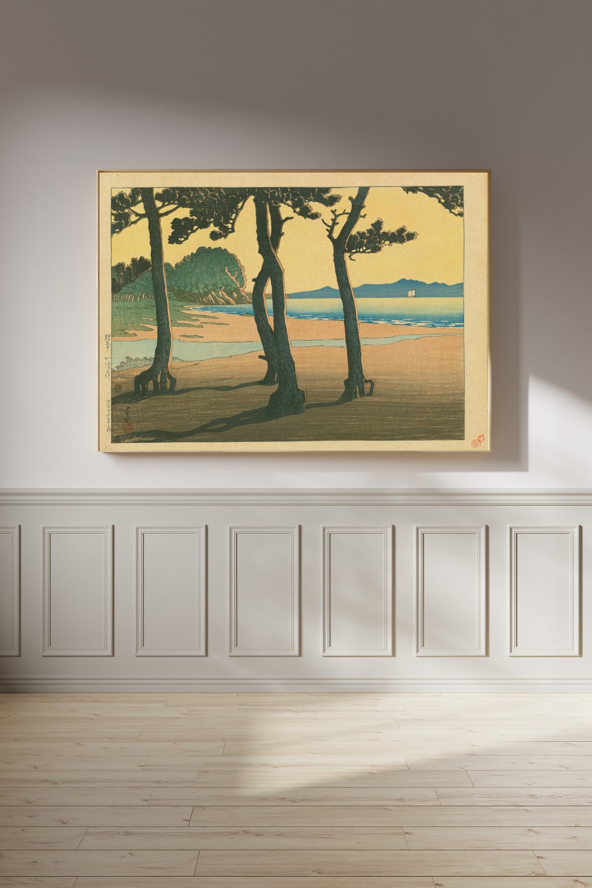 Framed art print of Kazusa Beach in Hizen Province by Kawase Hasui, on a panelled wall in afternoon light