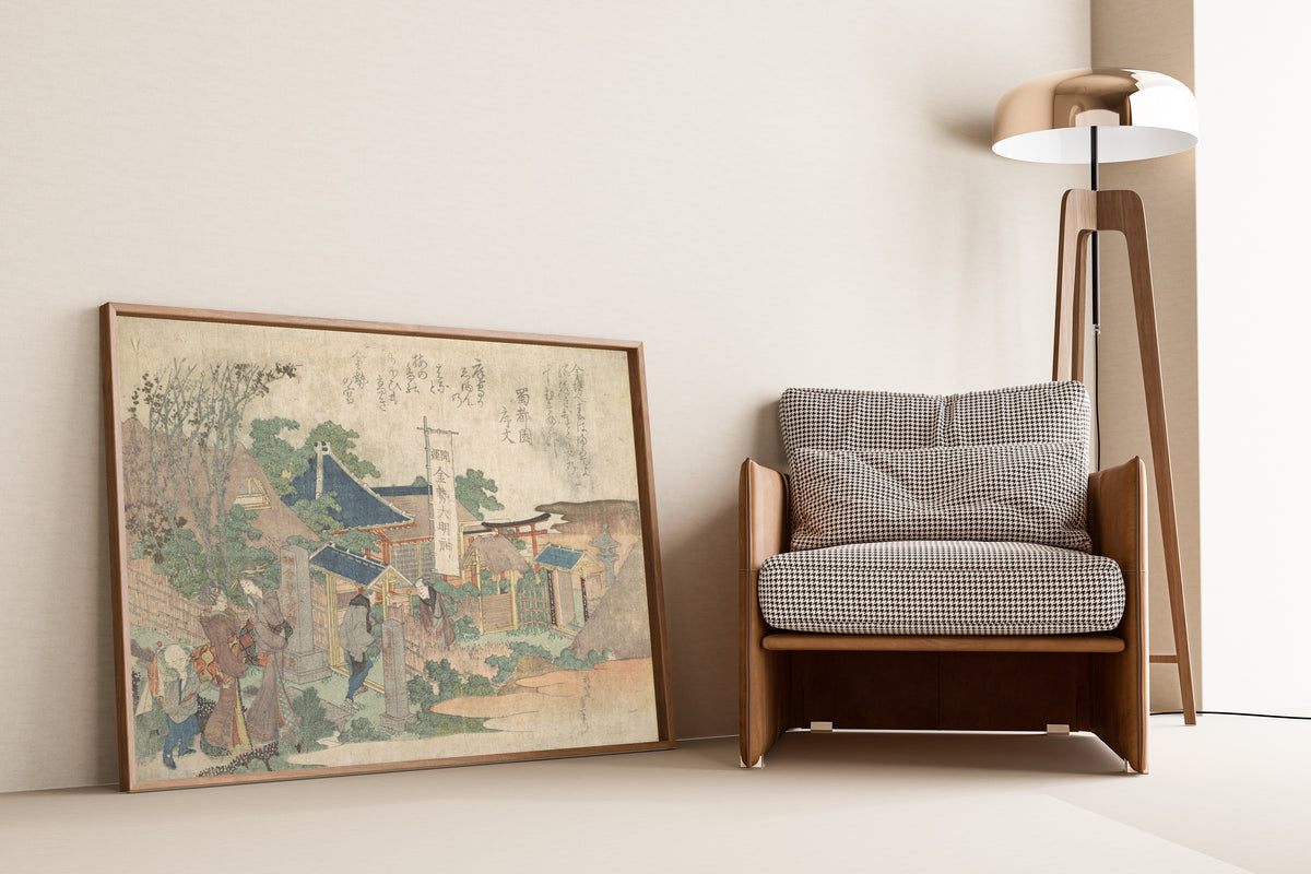 Framed art print of Konsei Daimyōjin Shrine by Katsushika Hokusai, leaning against a wall beside an armchair and a floor lamp