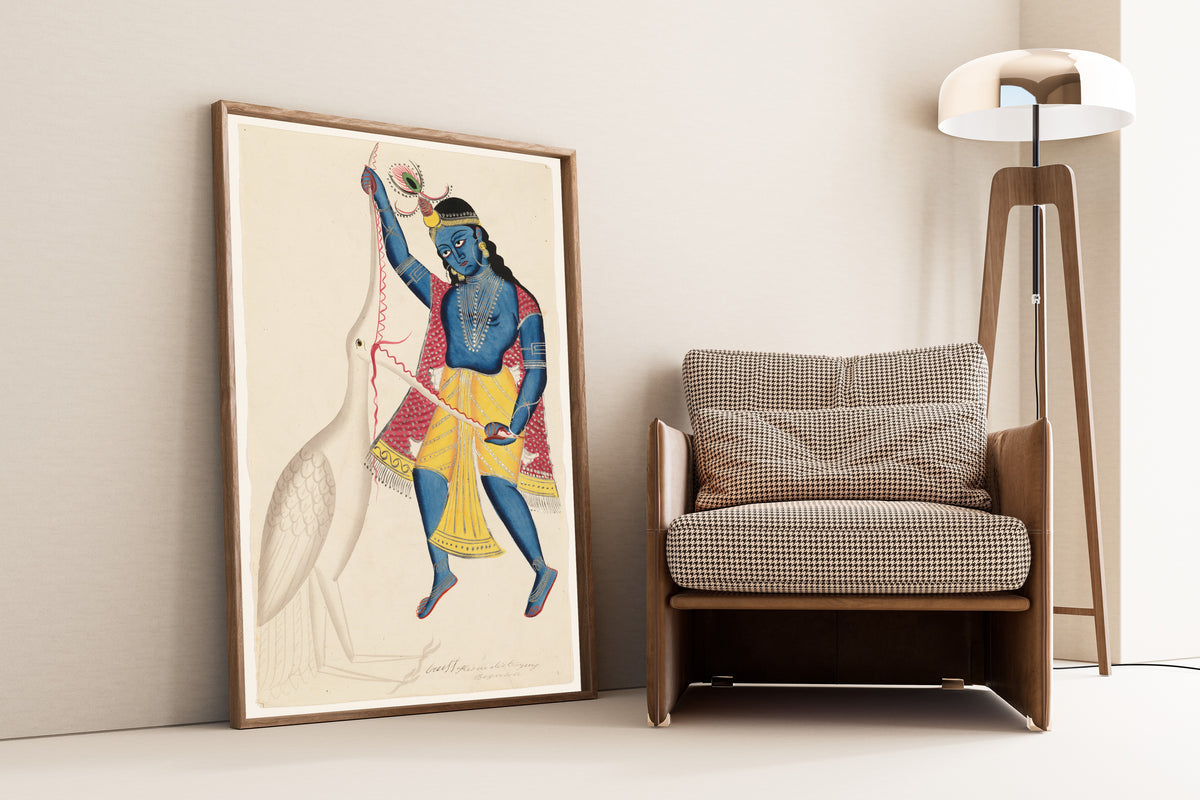 Framed art print of Krishna Killing Bakasura by Kalighat painter, leaning against a wall beside an armchair and a floor lamp