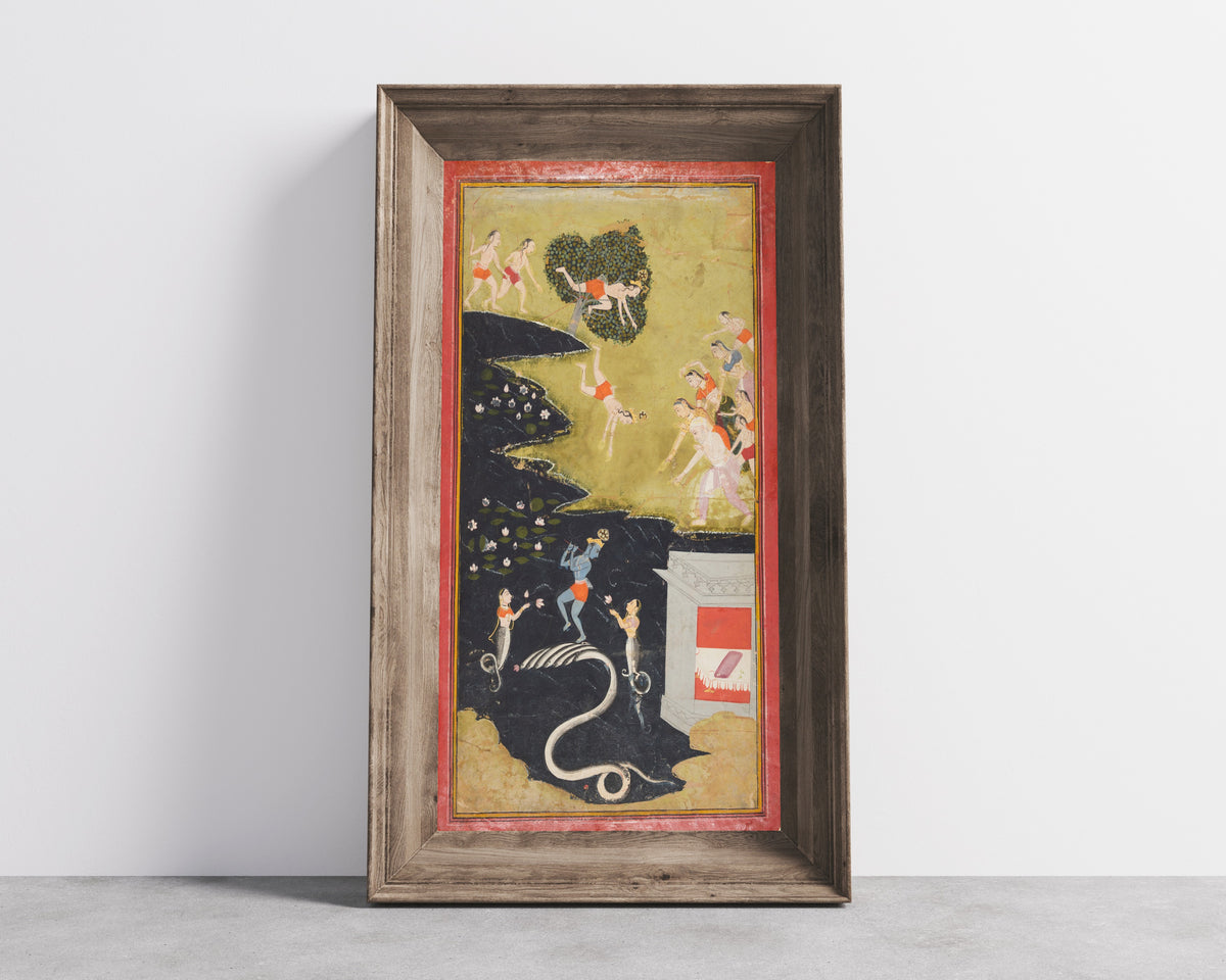 Framed art print of Krishna Quells the Serpent Kaliya by Mewar school, in a wide wooden frame leaning against a concrete wall