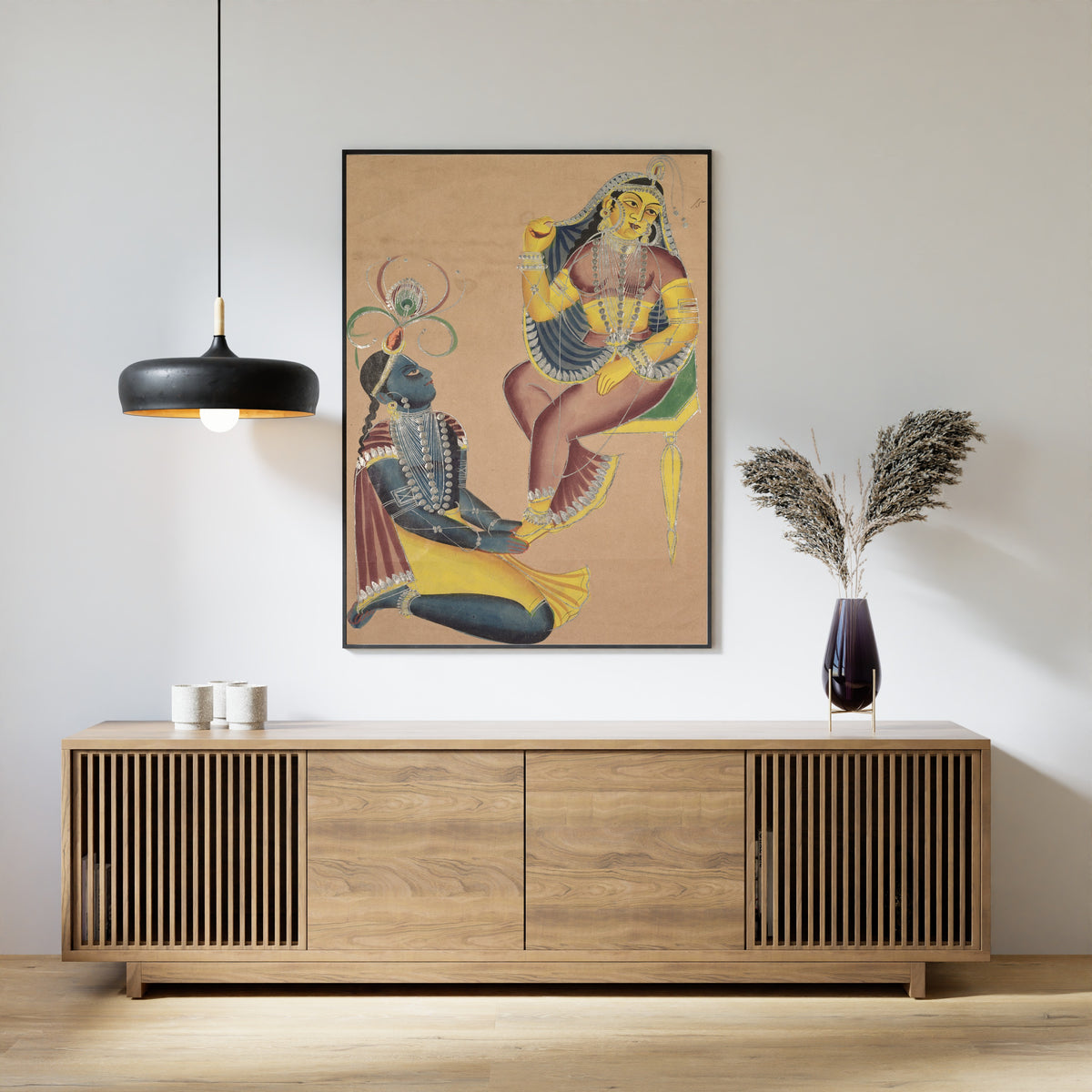 Framed art print of Krishna Stroking Radha's Feet by Kalighat painter, above a slatted wood sideboard