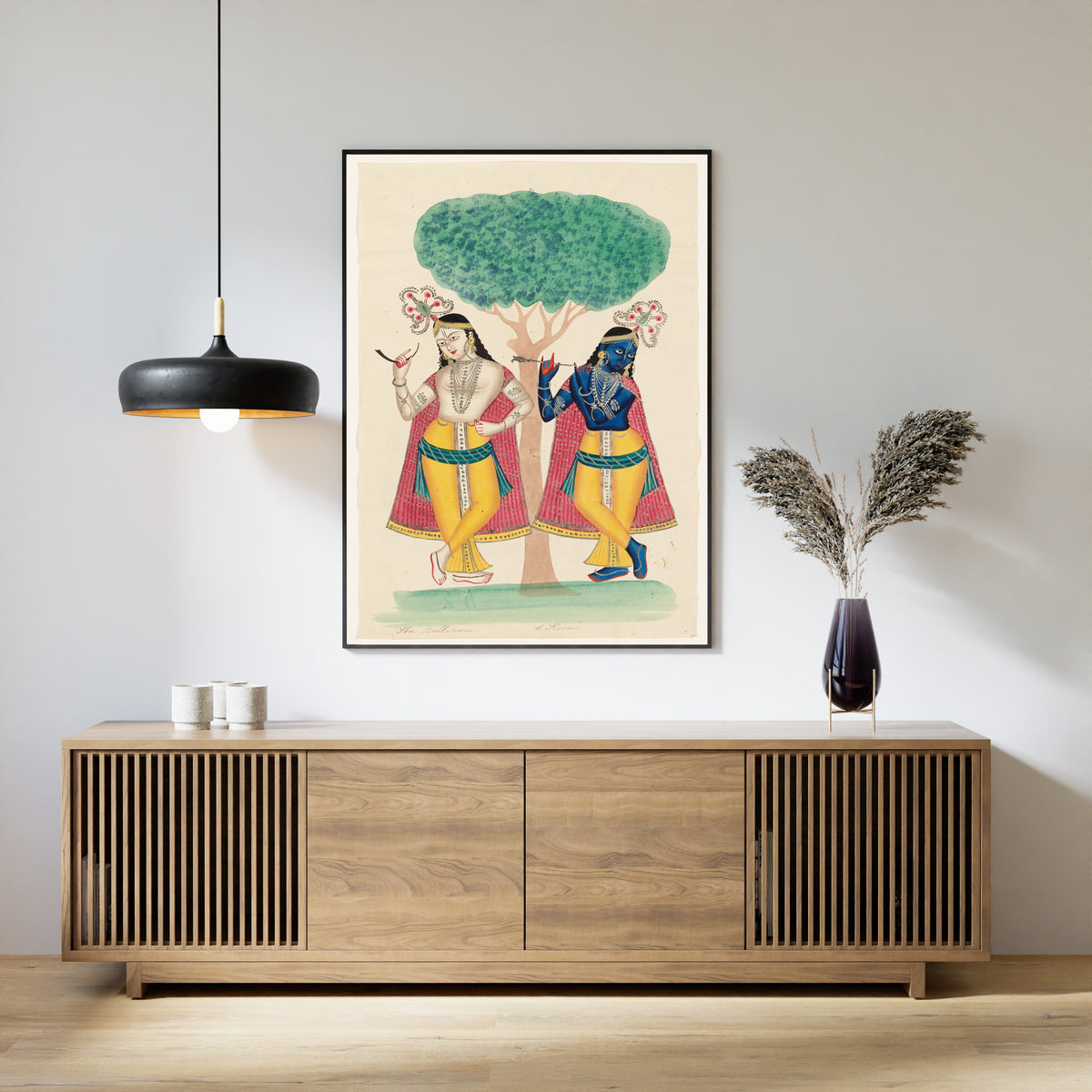 Framed art print of Krishna and Balarama underneath a Tree by Kalighat painter, above a slatted wood sideboard