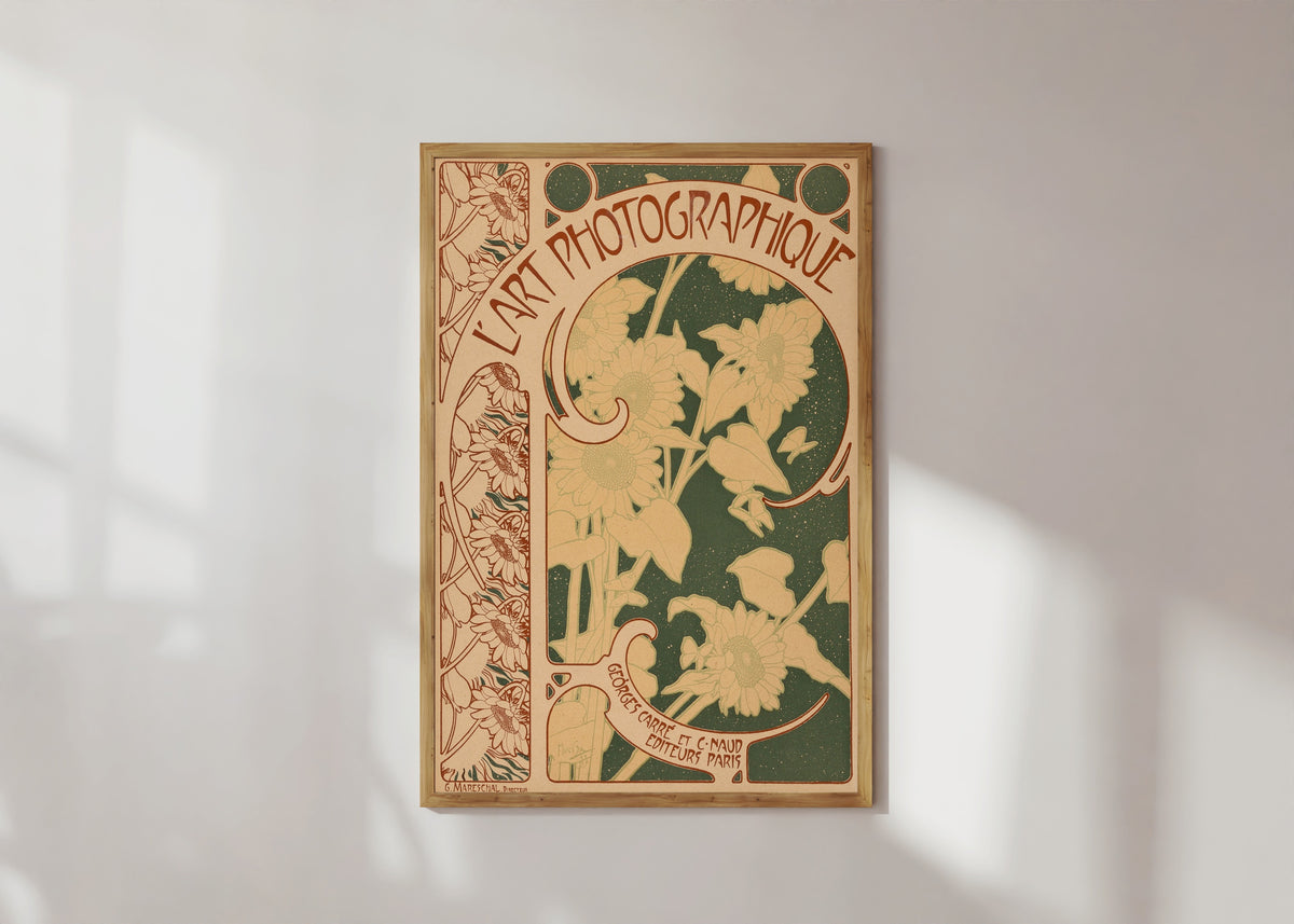 Framed art print of L’Art Photographique, no. 10 (cover) by Alphonse Mucha, in a light wood frame on a sunlit white wall