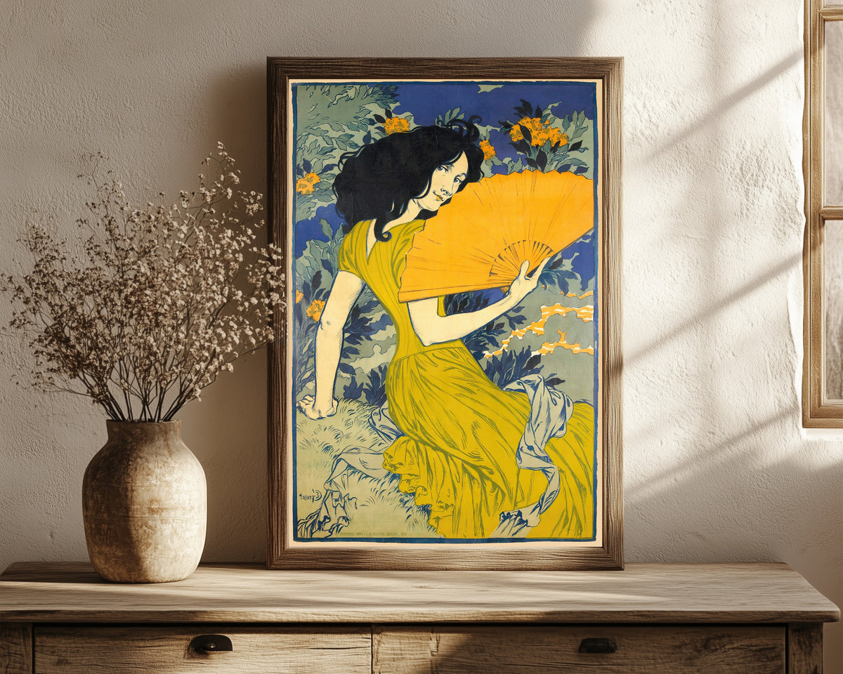 Framed art print of L'Éventail by Eugène Grasset, in a dark wood frame leaning on a rustic console beside dried flowers