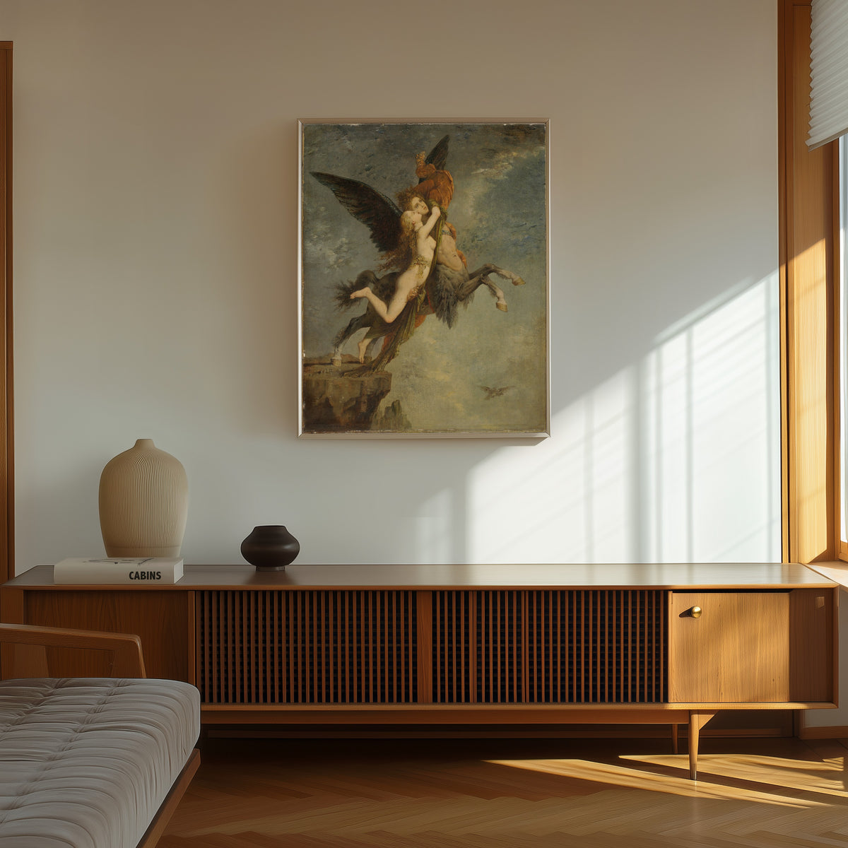 Framed art print of La Chimère by Gustave Moreau, in a thin light frame on a sunlit wall above a wooden sideboard