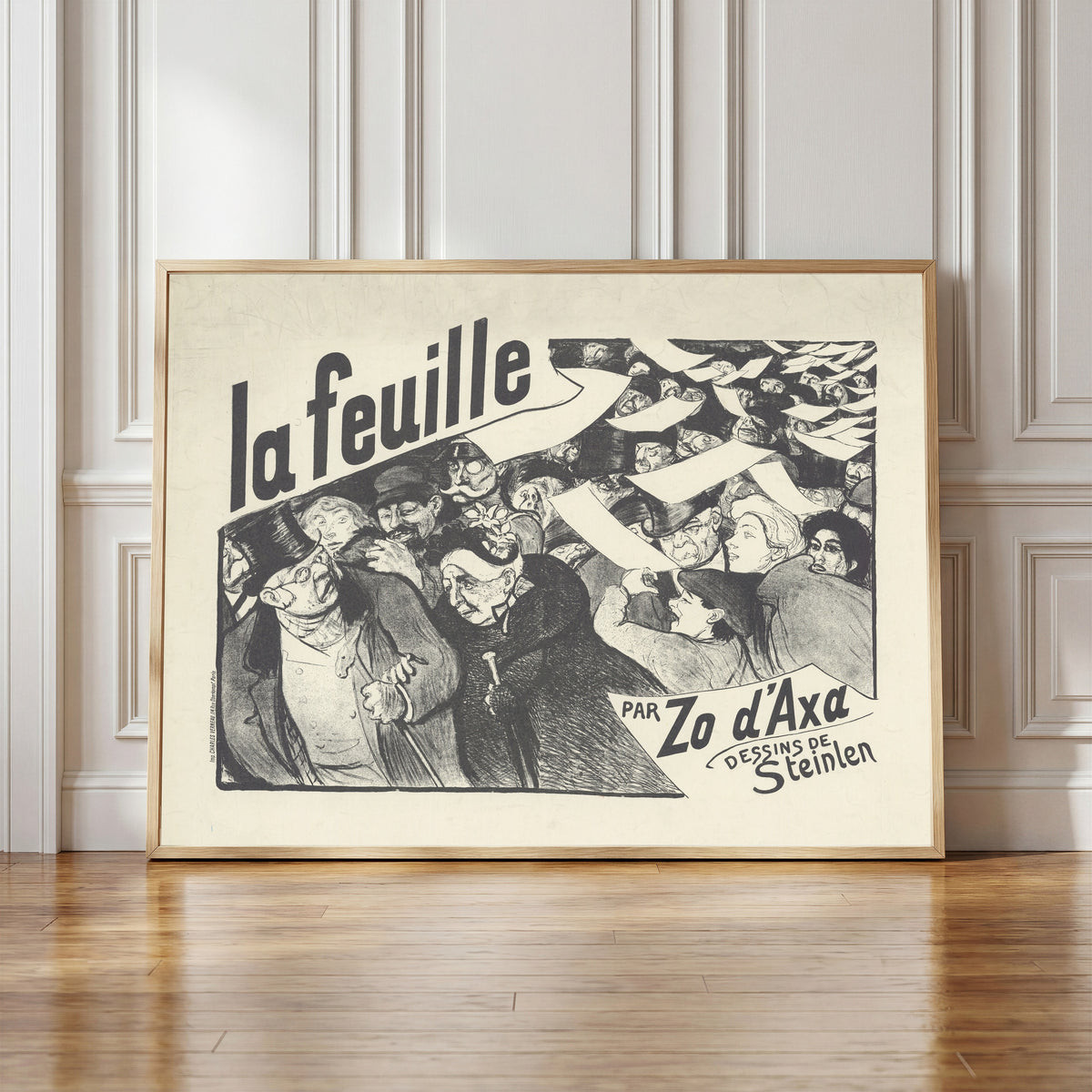 Framed art print of La Feuille, par Zo d’Axa, dessins de Steinlen by Théophile Steinlen, in a light wood frame leaning against a panelled white wall