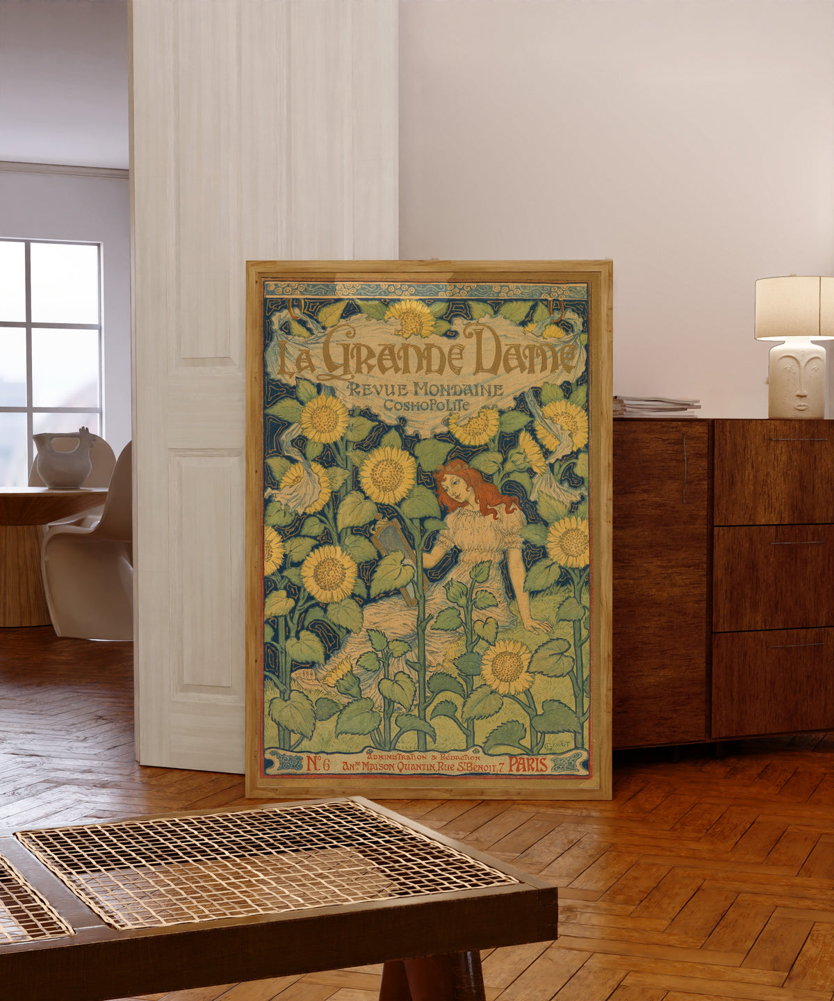 Framed art print of La Grande Dame by Eugène Grasset, in a light wood frame leaning in a warm room with a parquet floor