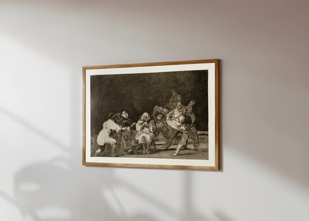Framed art print of La lealtad (Loyalty), from Los Disparates by Francisco de Goya, in a light wood frame on a sunlit white wall, seen at a slight angle