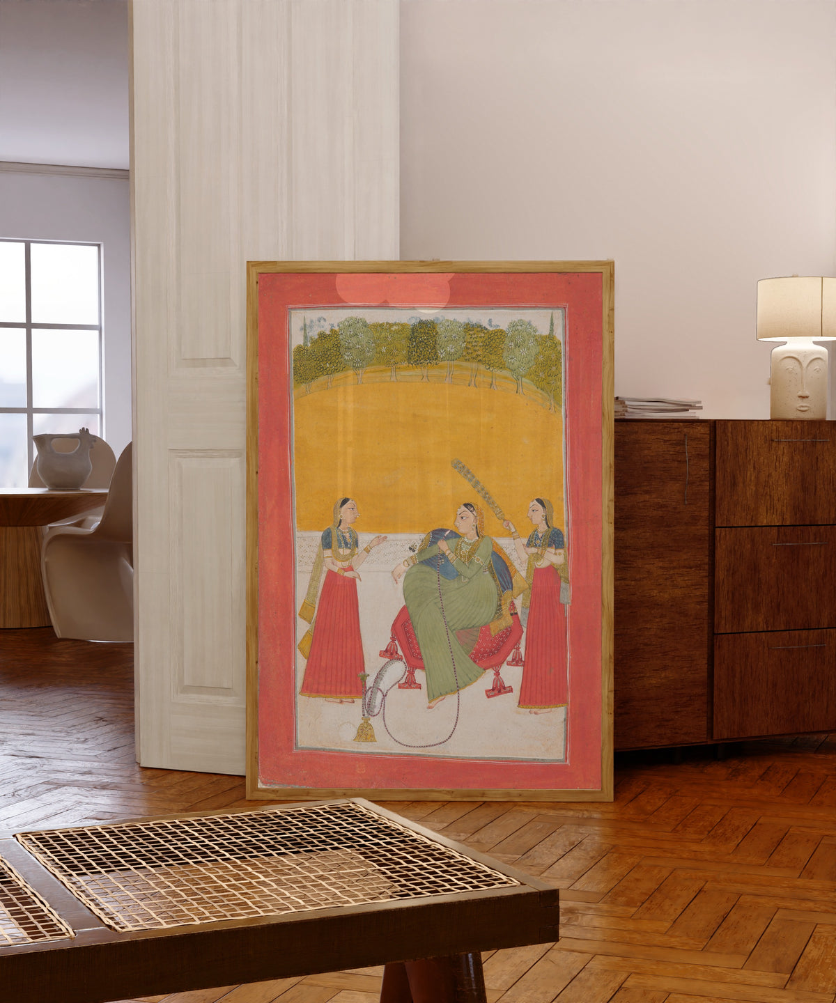 Framed art print of Lady on a Terrace by Chamba school, in a light wood frame leaning in a warm room with a parquet floor