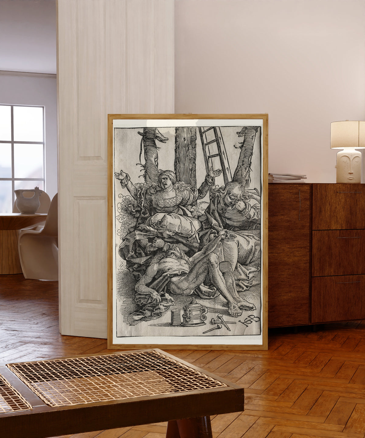 Framed art print of Lamentation by Hans Baldung Grien, in a light wood frame leaning in a warm room with a parquet floor