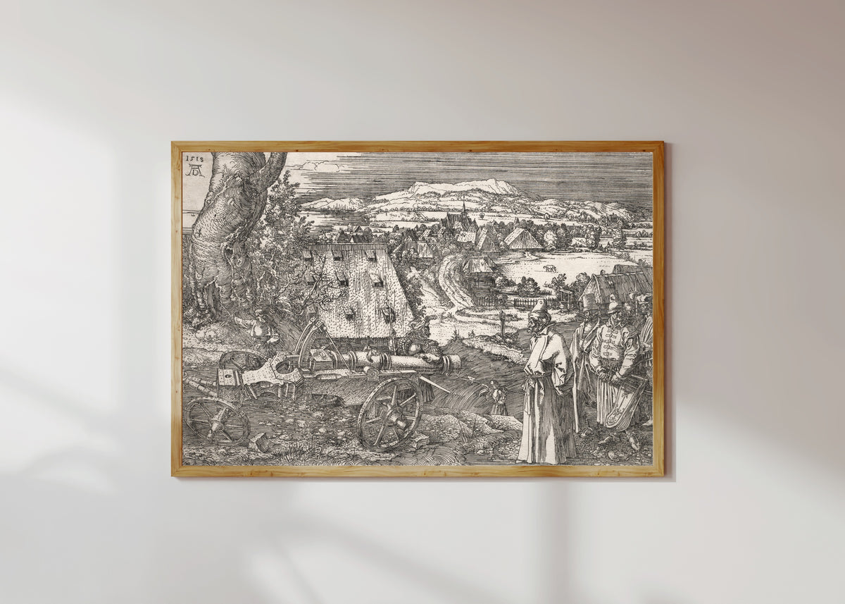Framed art print of Landscape with the Cannon by Albrecht Dürer, in a light wood frame on a sunlit white wall