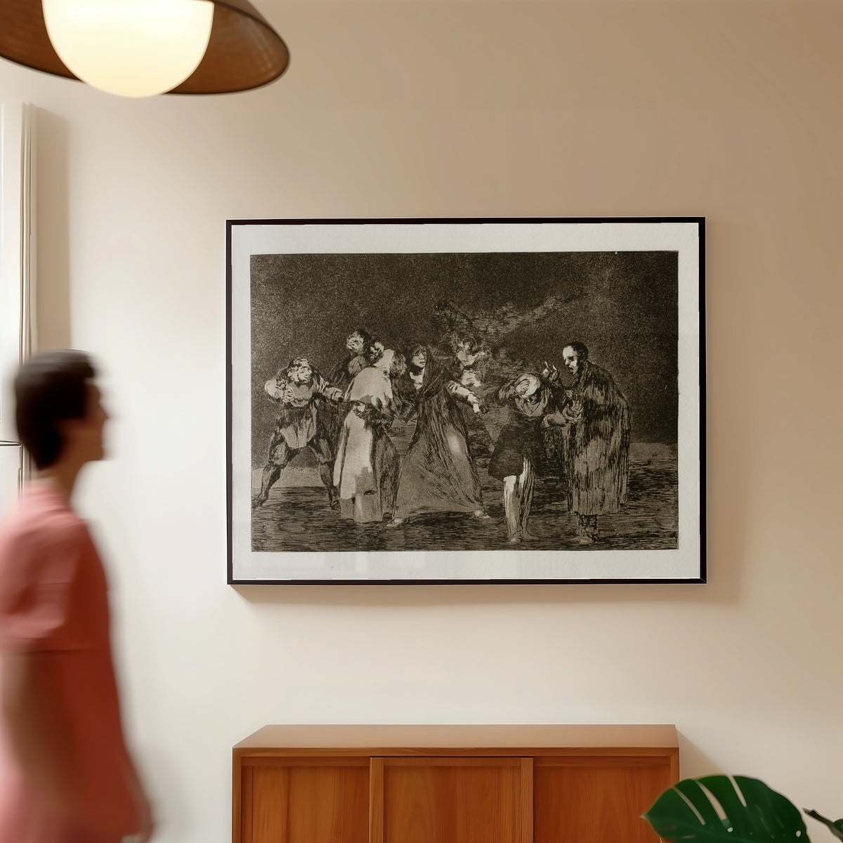 Framed art print of Las exhortaciones (The Exhortations), from Los Disparates by Francisco de Goya, in a slim black frame on a warm wall in a sunlit room
