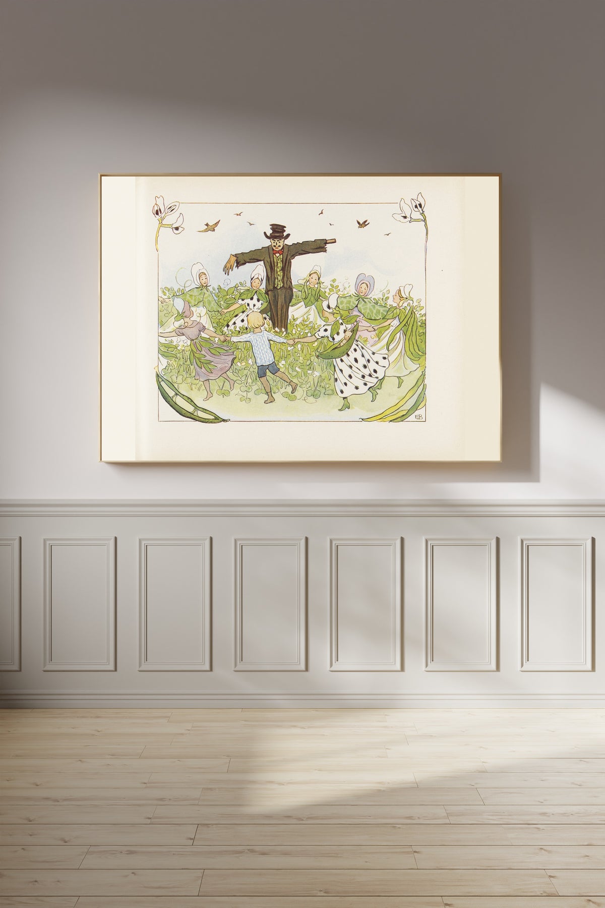 Framed art print of Lasse in the Ring Dance round the Scarecrow by Elsa Beskow, on a panelled wall in afternoon light