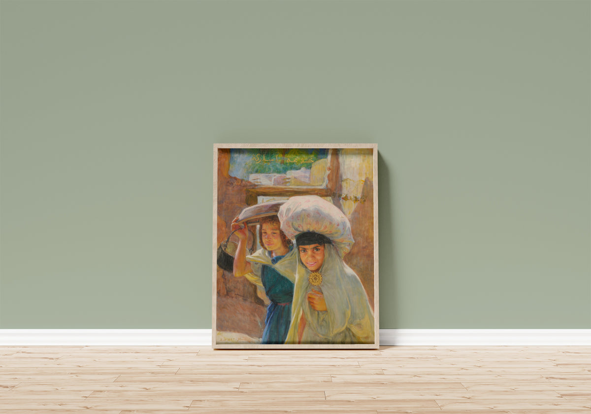 Framed art print of Laveuses by Étienne Dinet, in a light wood frame leaning on a sage green wall above a wooden floor