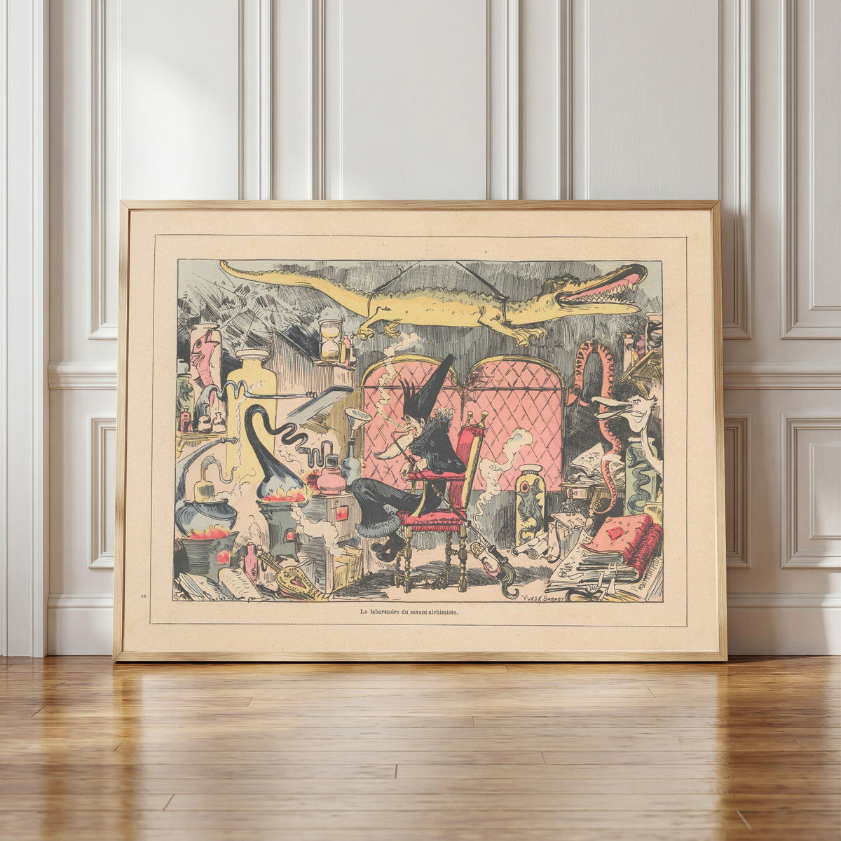 Framed art print of Le laboratoire du savant alchimiste by Albert Robida, in a light wood frame leaning against a panelled white wall