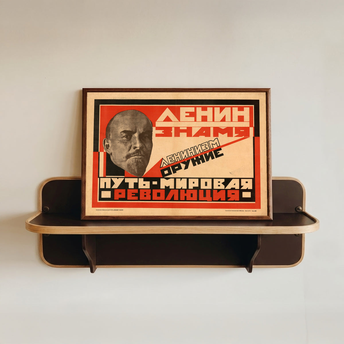 Framed art print of Lenin is the banner. Leninism is the weapon. The path is world revolution, in a dark wood frame resting on a wall shelf
