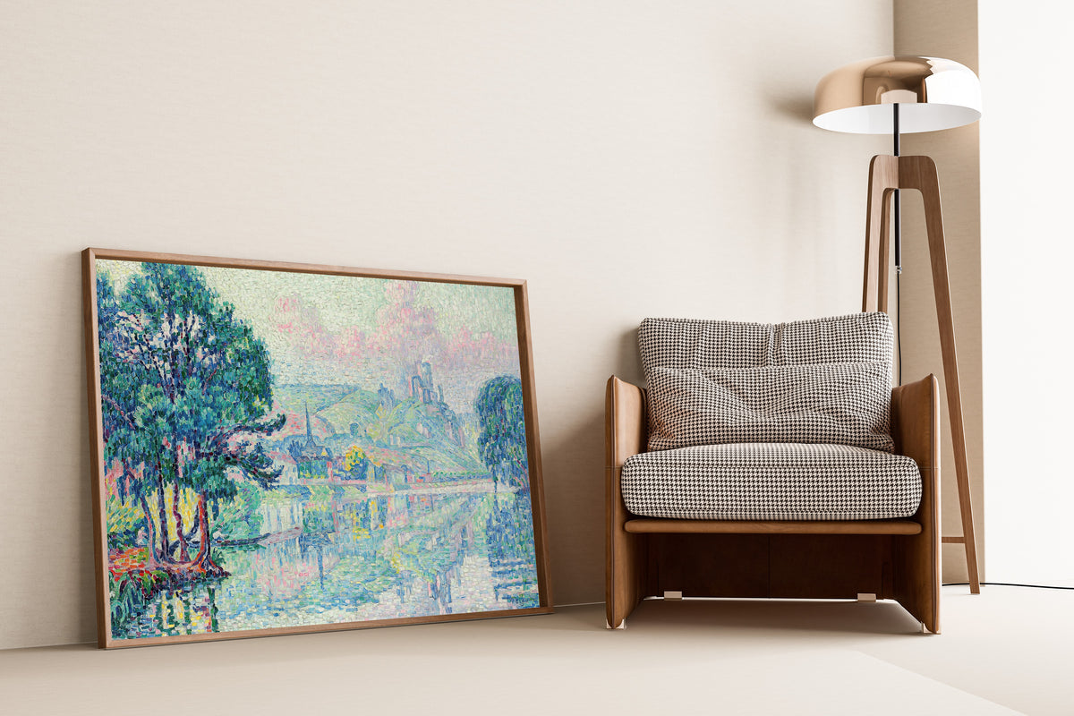 Framed art print of Les Andelys, Morning, Summer by Paul Signac, leaning against a wall beside an armchair and a floor lamp