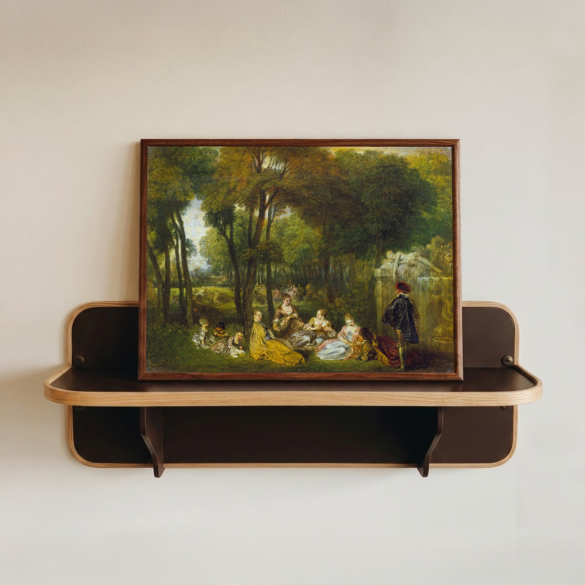 Framed art print of Les Champs Élysées by Jean-Antoine Watteau, in a dark wood frame resting on a wall shelf