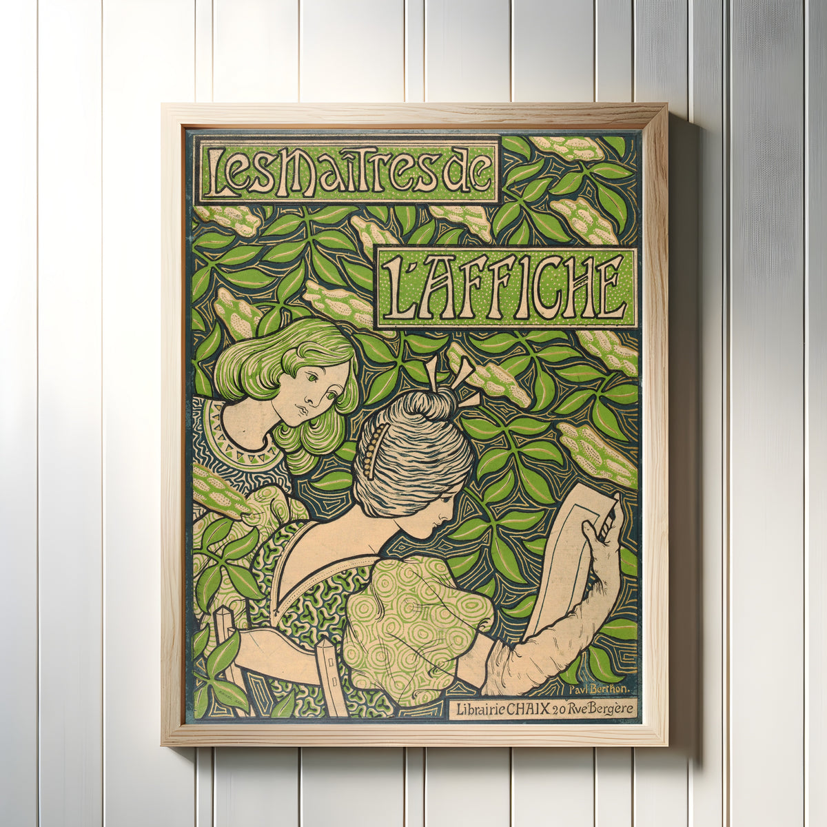 Framed art print of Les Maîtres de l'Affiche (cover) by Paul Berthon, in a light wood frame on a white panelled wall