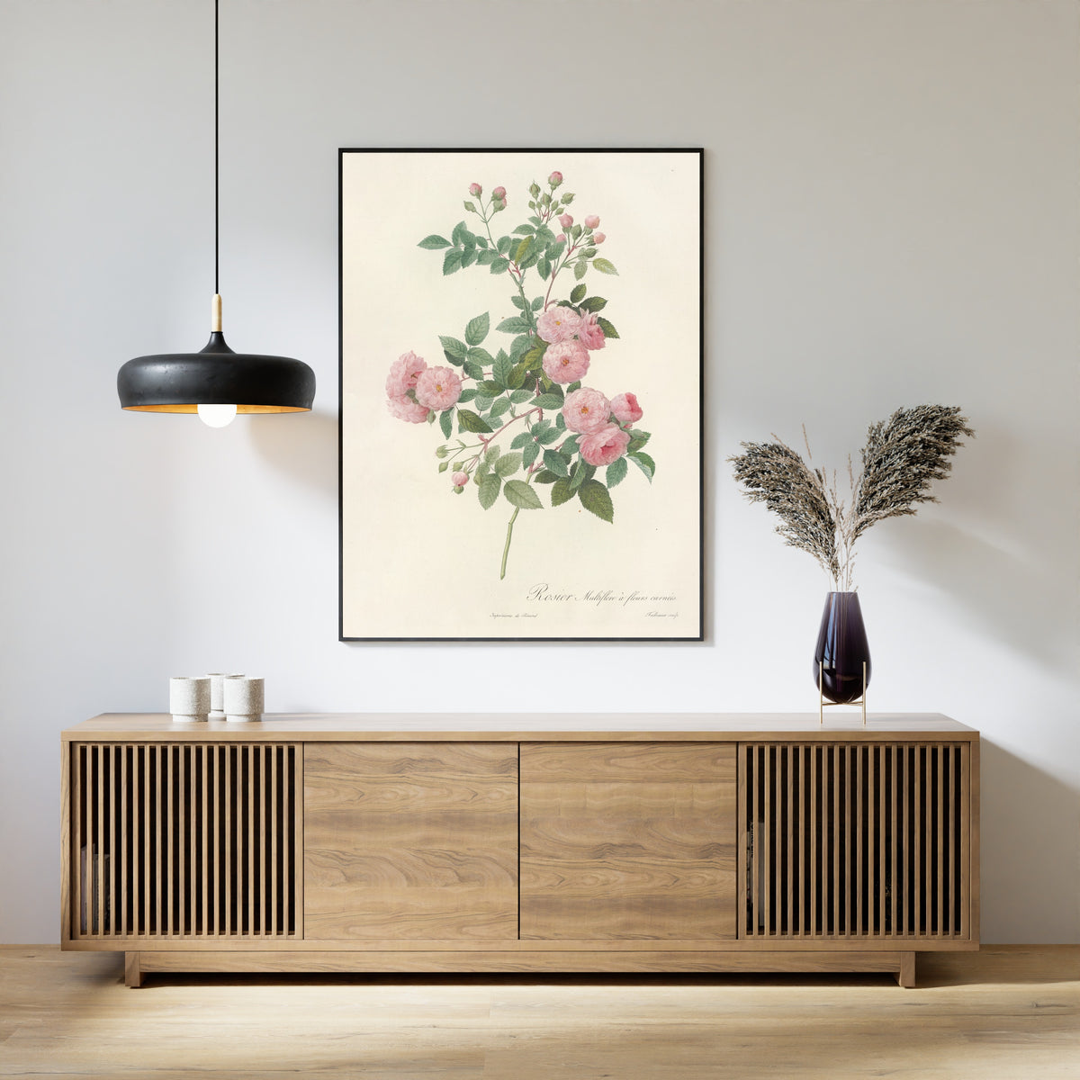Framed art print of Les Roses: Rosa Multiflora Carnea by Pierre-Joseph Redouté, above a slatted wood sideboard