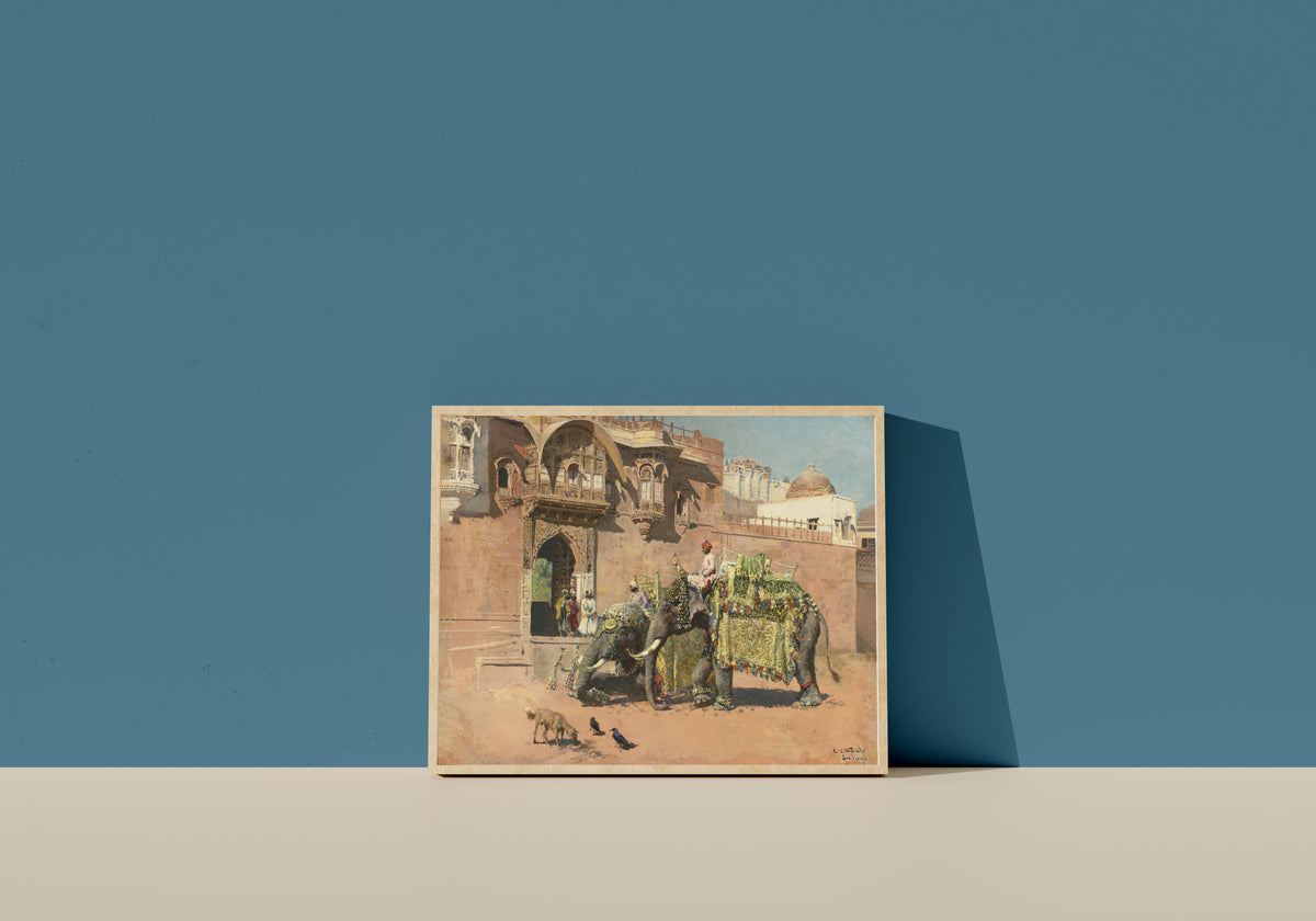 Framed art print of Les éléphants du Rajah de Jodhpore by Edwin Lord Weeks, in a light wood frame leaning on a blue wall