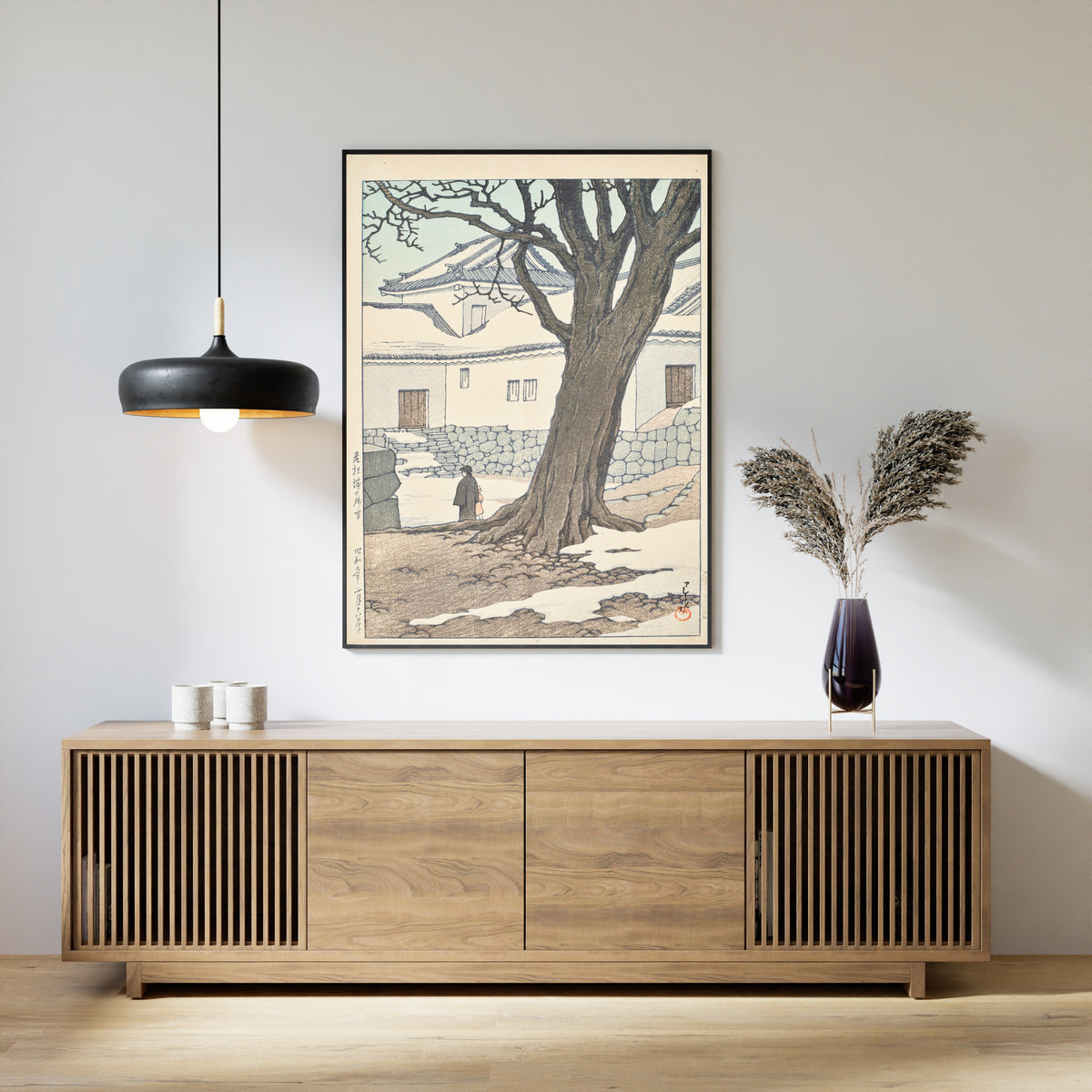 Framed art print of Lingering Snow at Hikone Castle by Kawase Hasui, above a slatted wood sideboard