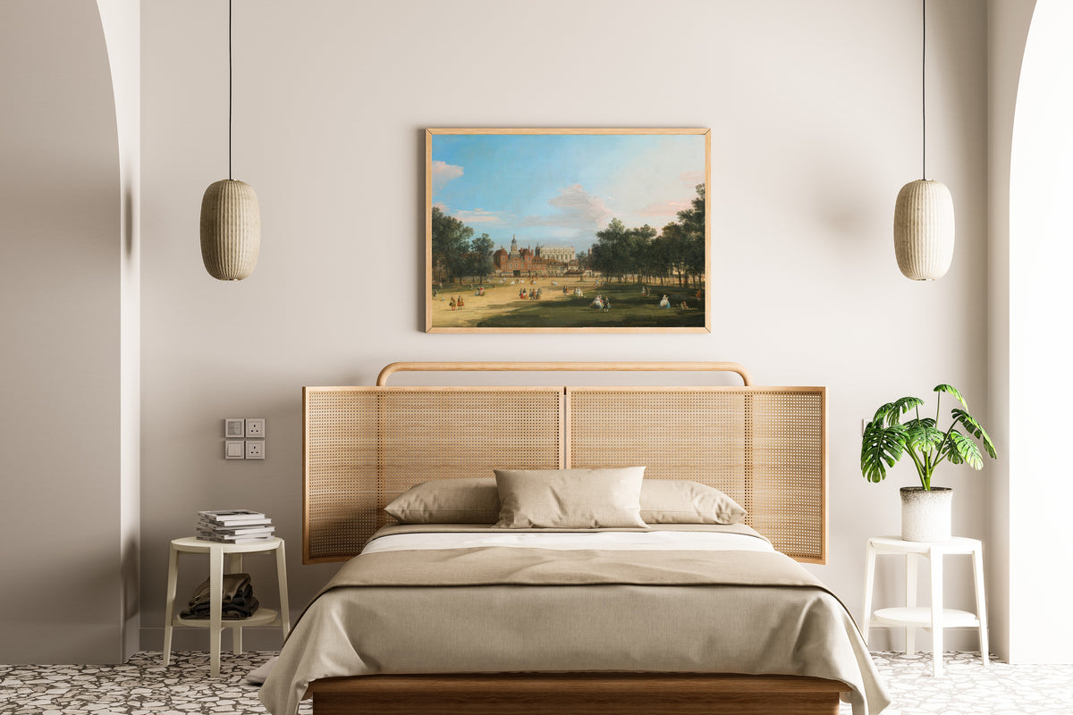 Framed art print of London, A View of the Old Horse Guards and Banqueting Hall, Whitehall Seen from St. James’ Park by Canaletto, above a cane-headboard bed