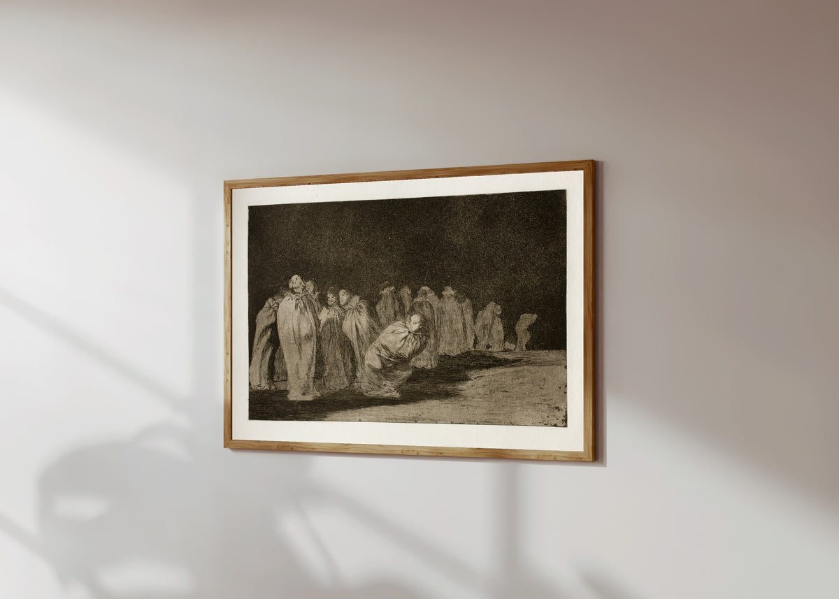 Framed art print of Los ensacados (The Men in Sacks), from Los… by Francisco de Goya, in a light wood frame on a sunlit white wall, seen at a slight angle