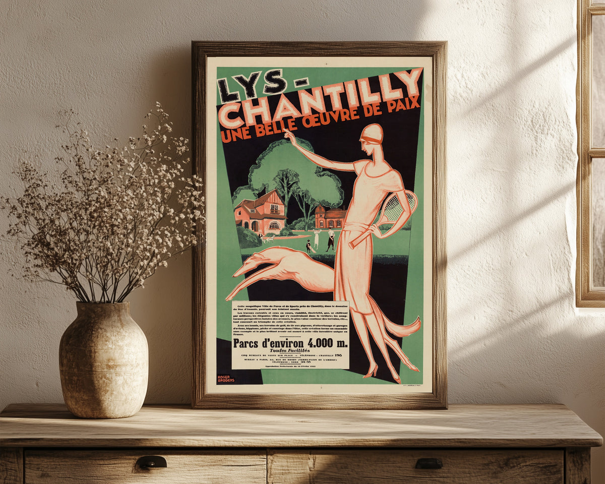Framed art print of Lys-Chantilly: une belle œuvre de paix by Roger Broders, in a dark wood frame leaning on a rustic console beside dried flowers