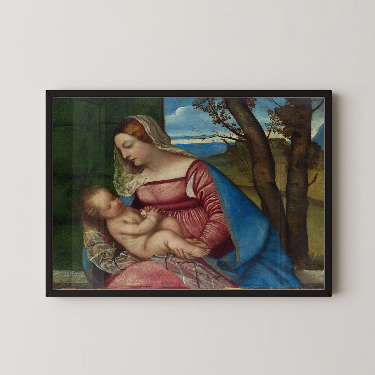 Framed art print of Madonna and Child by Titian, in a black frame on a pale wall