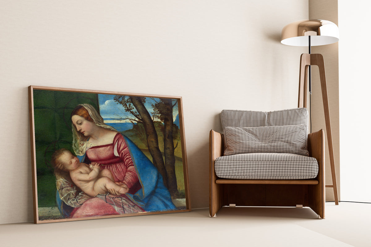 Framed art print of Madonna and Child by Titian, leaning against a wall beside an armchair and a floor lamp