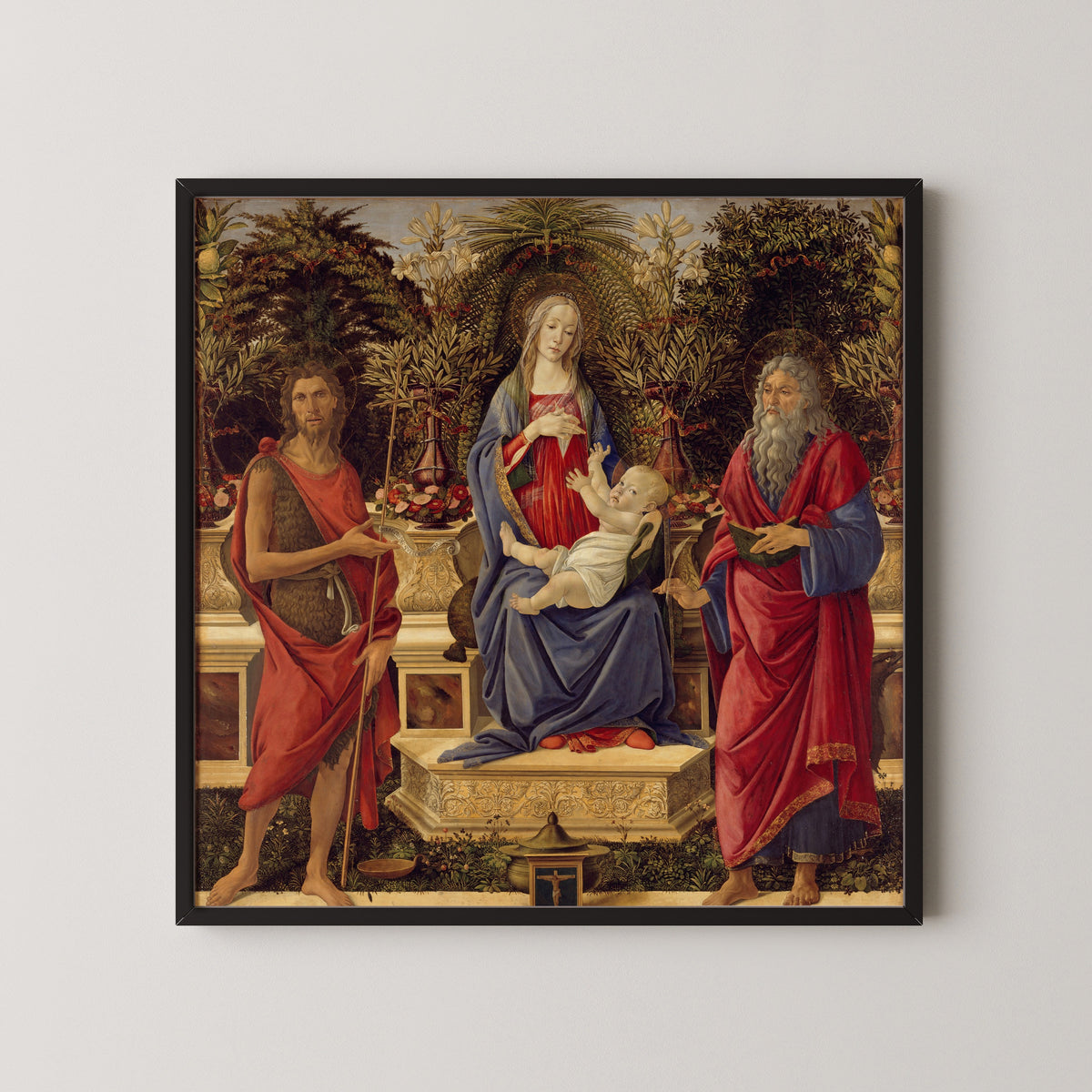 Framed art print of Madonna and Child with both Saints John by Sandro Botticelli, in a black frame on a pale wall
