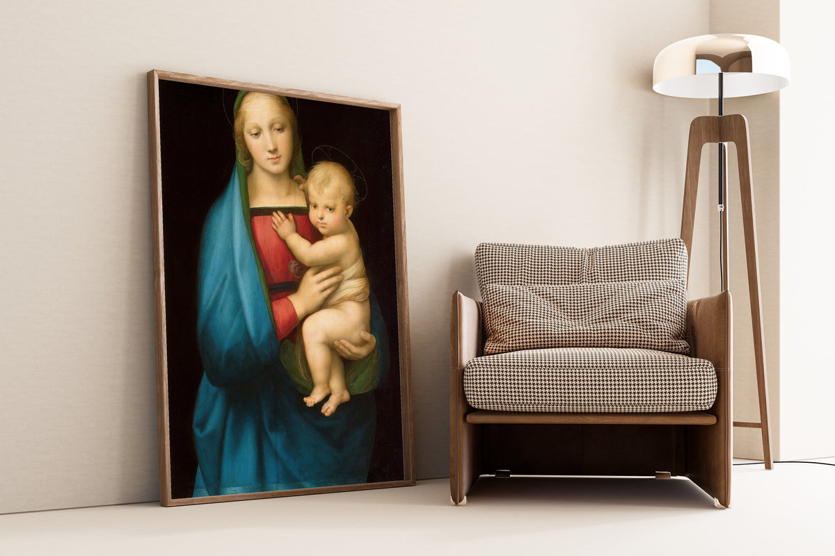 Framed art print of Madonna del Granduca by Raphael, leaning against a wall beside an armchair and a floor lamp