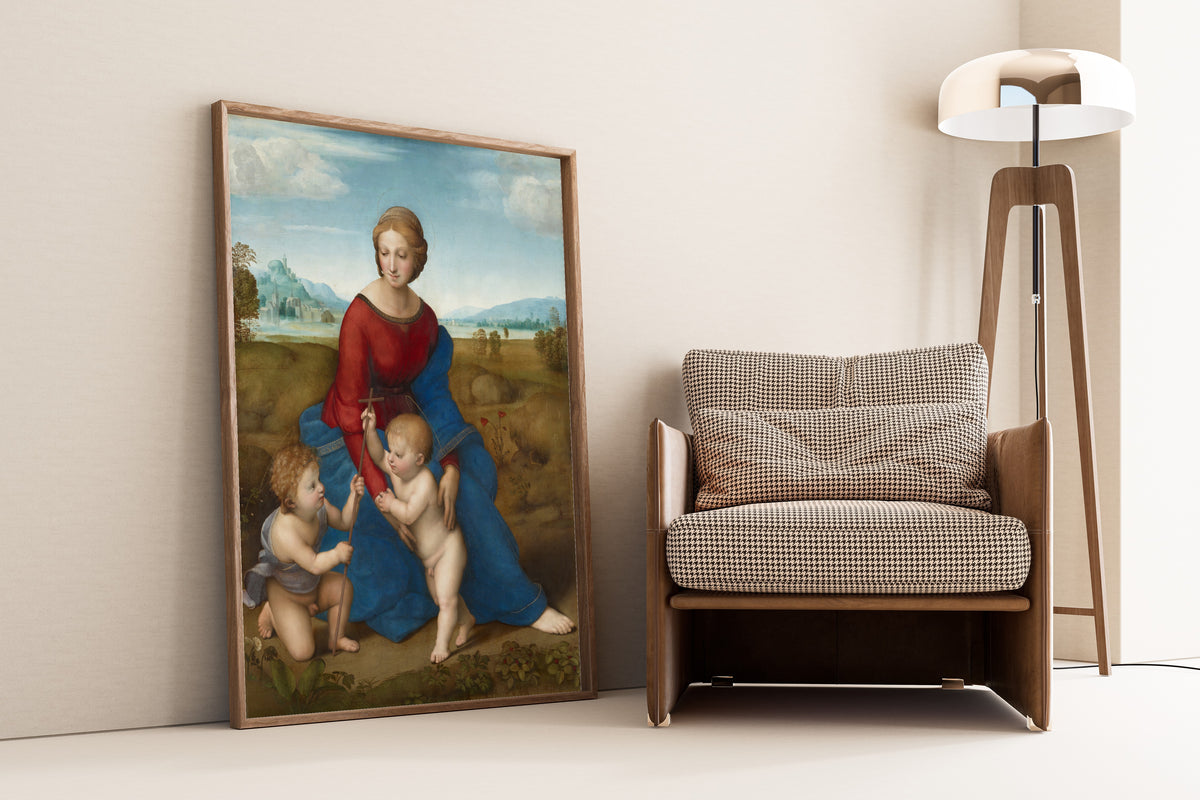 Framed art print of Madonna in the Meadow by Raphael, leaning against a wall beside an armchair and a floor lamp
