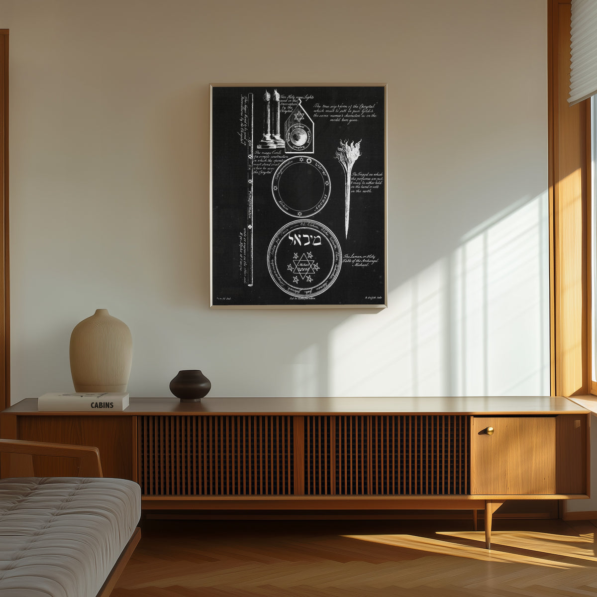 Framed art print of Magical Symbols and Instruments by Francis Barrett, in a thin light frame on a sunlit wall above a wooden sideboard