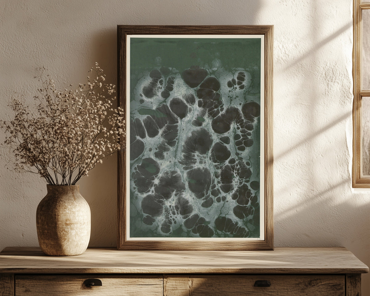 Framed art print of Marmorpapier (black cells on dark green) by Otto Eckmann, in a dark wood frame leaning on a rustic console beside dried flowers