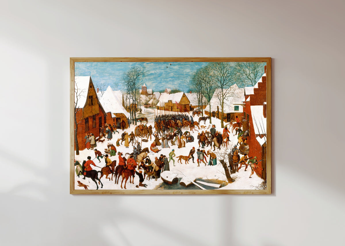 Framed art print of Massacre of the Innocents by Pieter Bruegel the Elder, in a light wood frame on a sunlit white wall