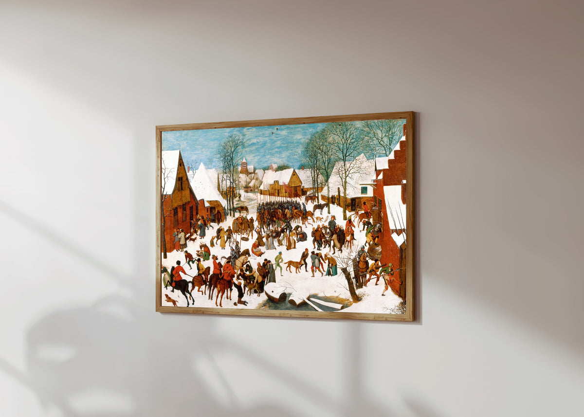 Framed art print of Massacre of the Innocents by Pieter Bruegel the Elder, in a light wood frame on a sunlit white wall, seen at a slight angle